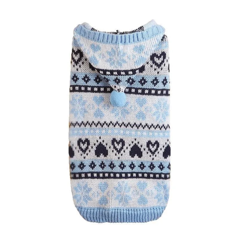 Pink knitted dog sweater with snowflake and striped camouflage patterns on a small Bichon dog