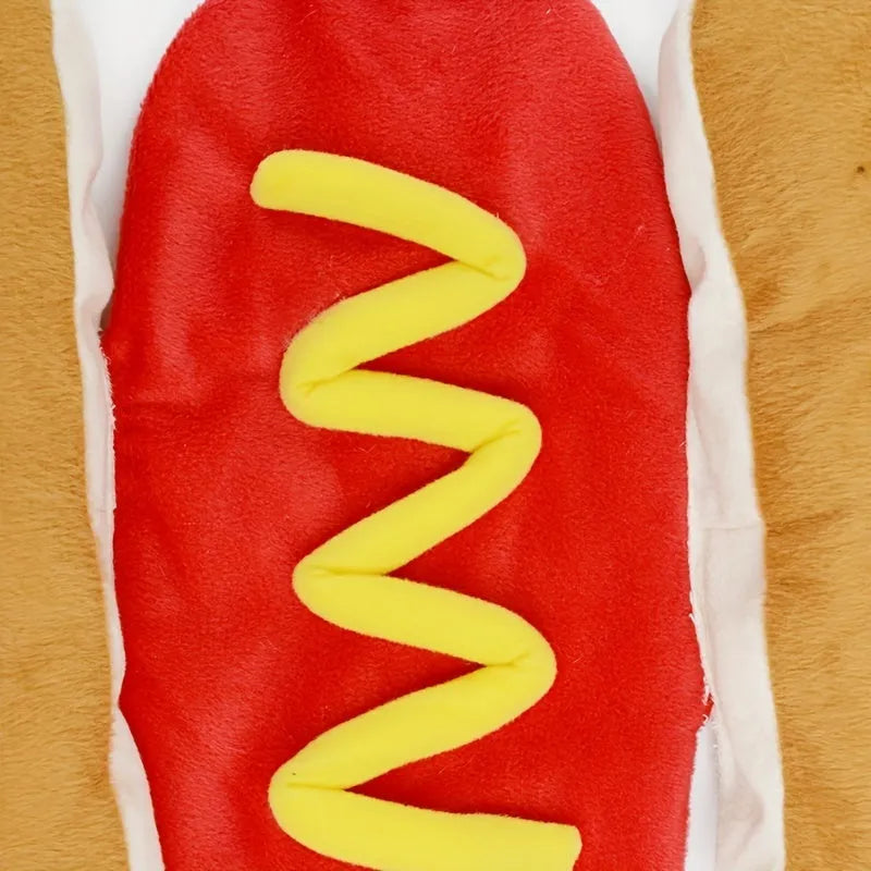 A small dog wearing a plush red and brown hot dog costume with elastic straps.