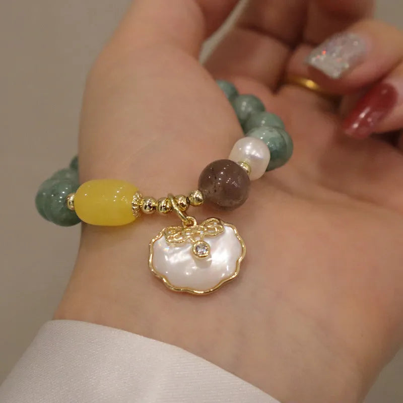 Natural green jade shell bracelet on display showing shell-shaped stone pieces in pictured colour