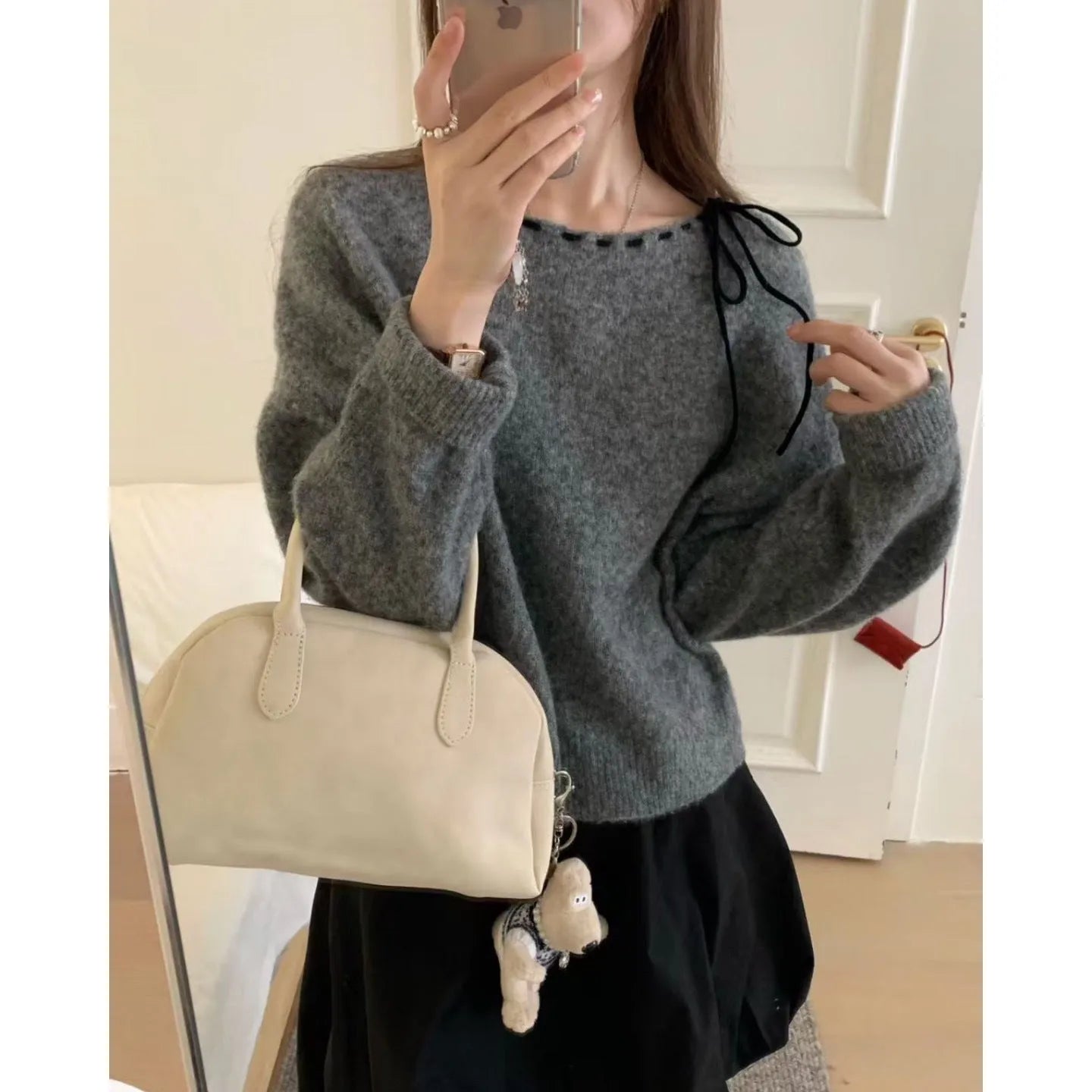Women's loose-fitting grey knitwear pullover top with long sleeves on a hanger