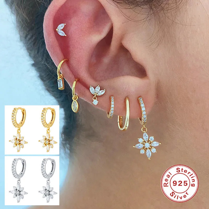 Pair of Sterling Silver snowflake pendant earrings on a yellow or white gold colour background.