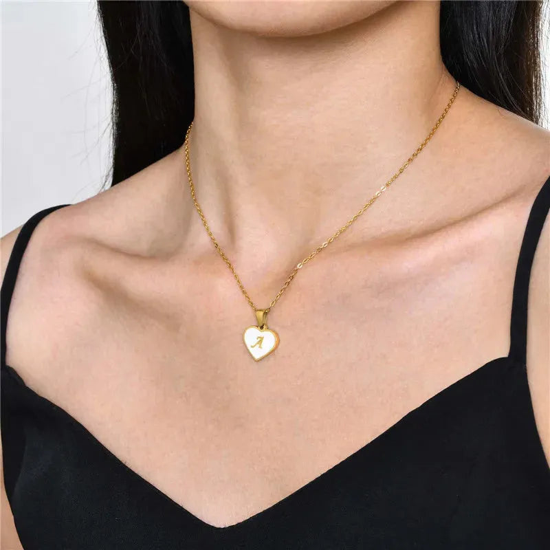 Gold heart-shaped white shell necklace with personalised letter charm on adjustable chain