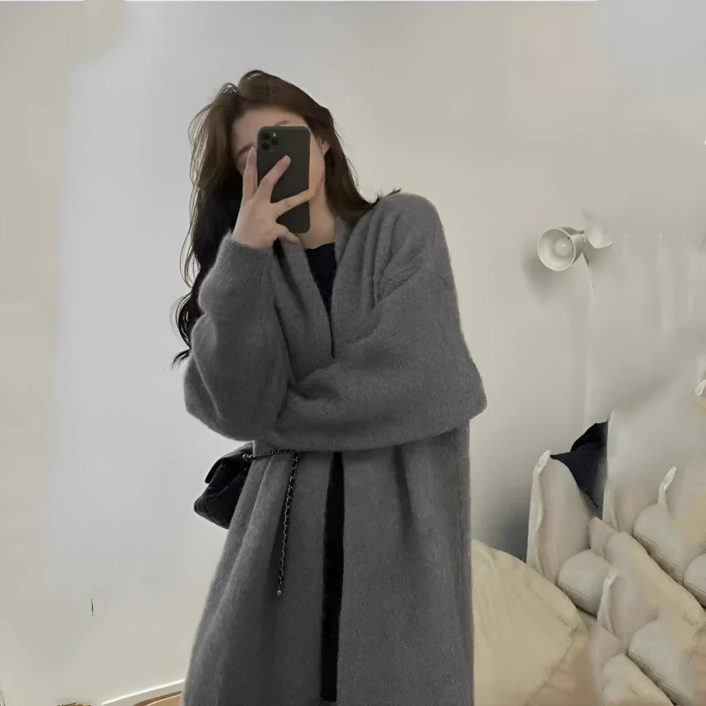Loose large knitted women's cardigan sweater in chenille fabric showing 3D stitch pattern.