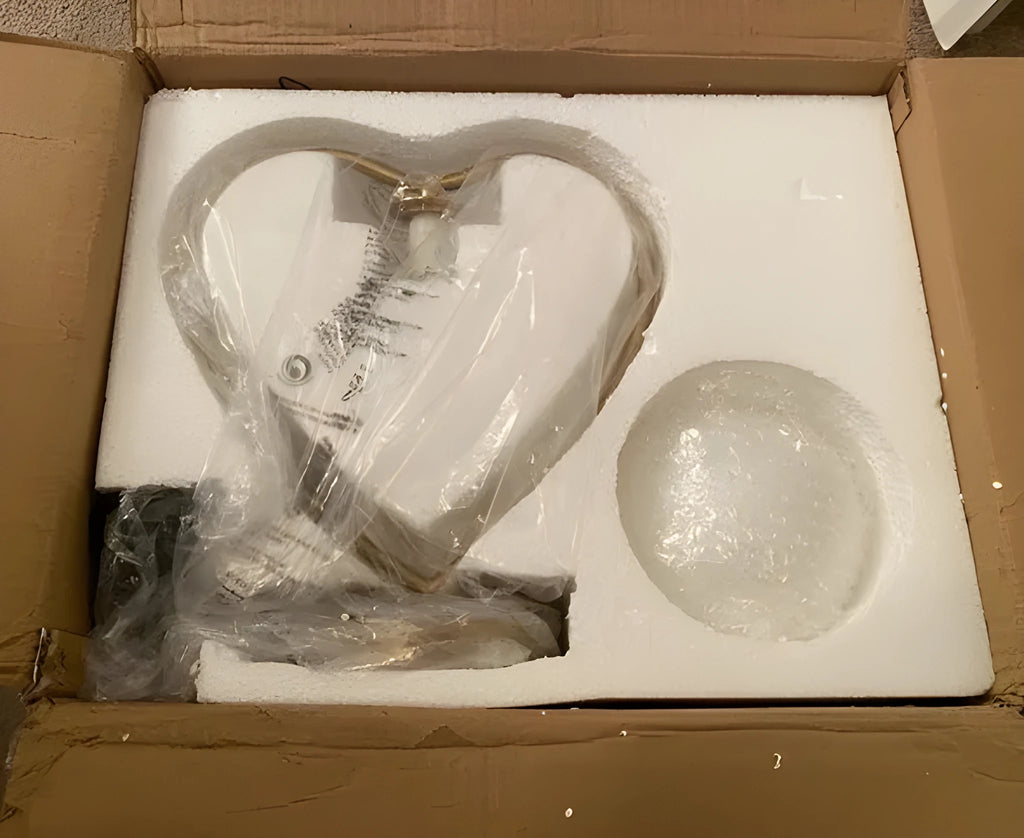 Heart shaped decorative LED lamp with polyresin base and frosted acrylic shade on a table.