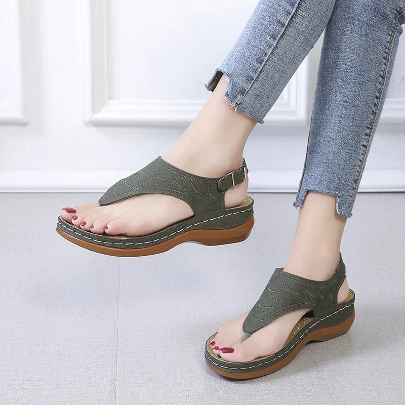 Women's black wedge heel sandals with an adjustable buckle strap on a light background.