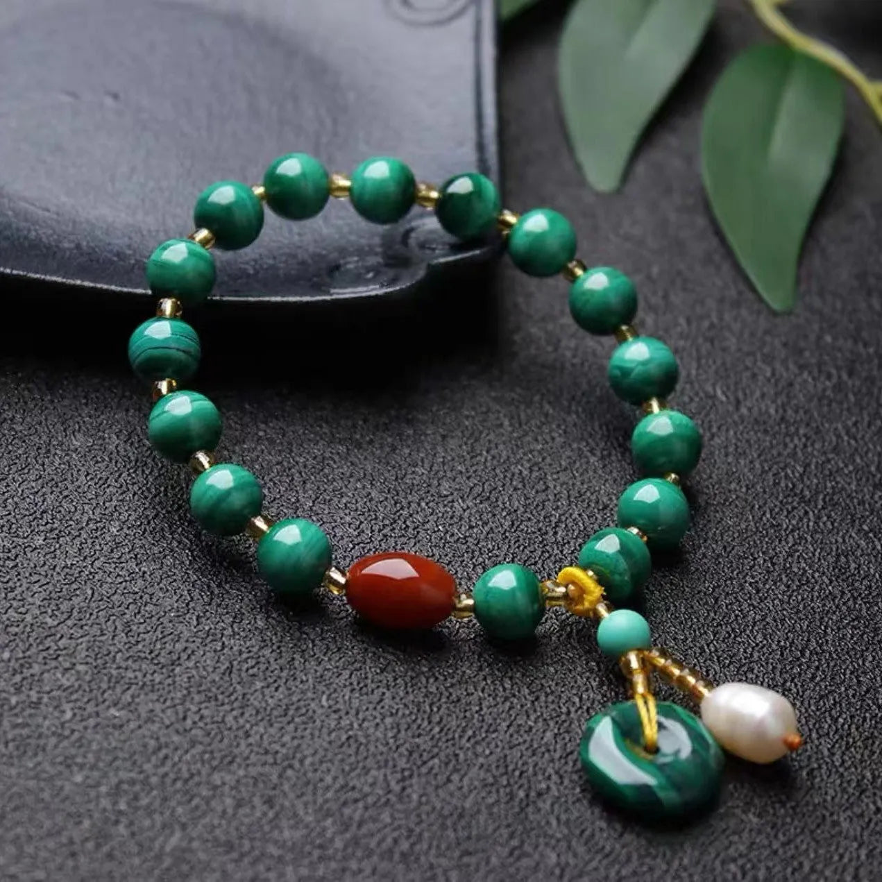 Natural malachite bracelet with green banded barrel beads on a neutral background