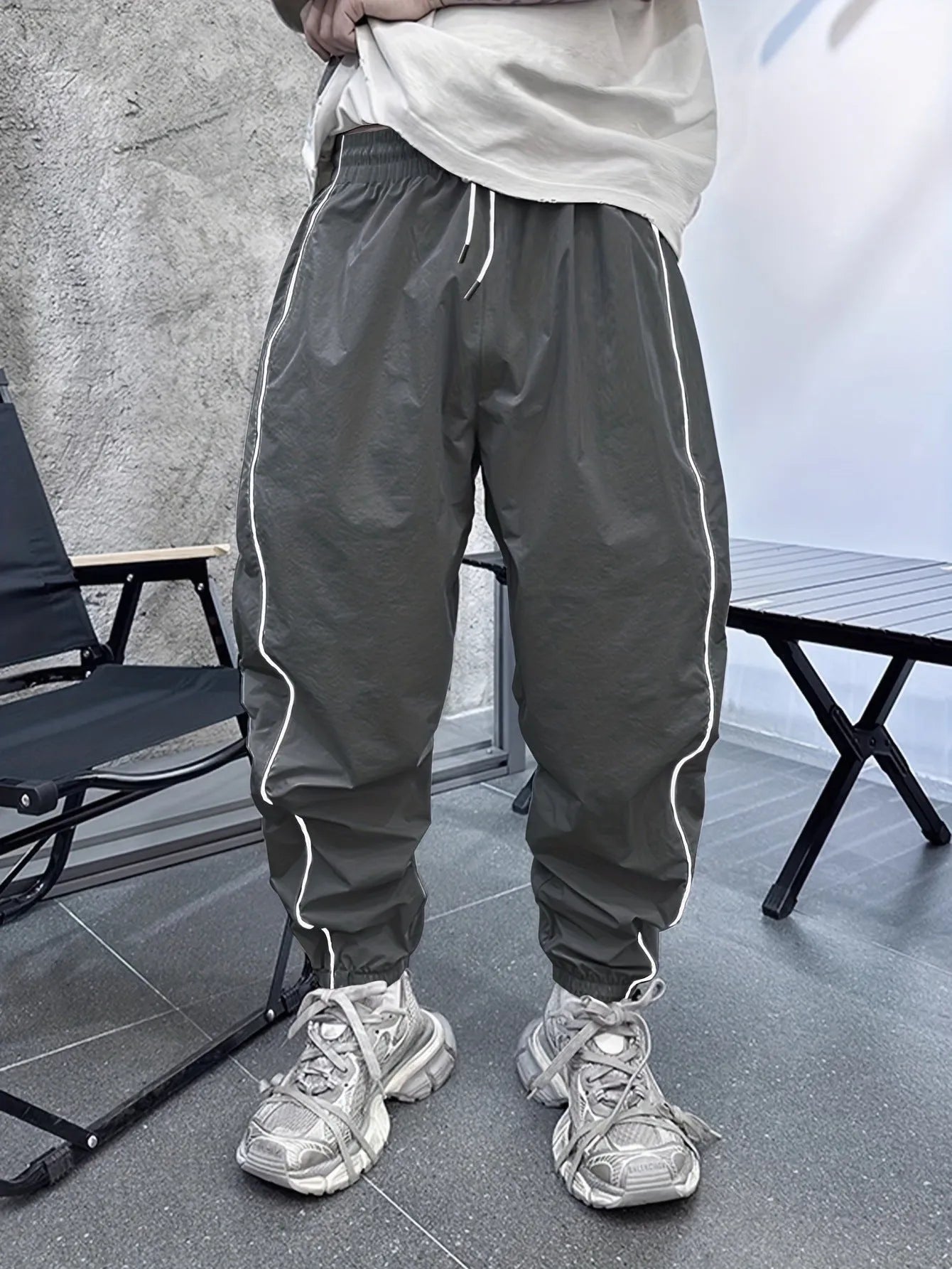 Man wearing loose-fit, cropped-length bamboo fibre sports trousers in a neutral colour.