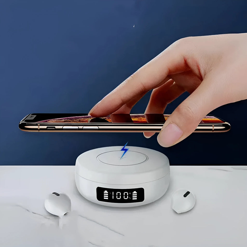 Mini black wireless semi-in-ear headphones sitting in their open white charging case on a table.