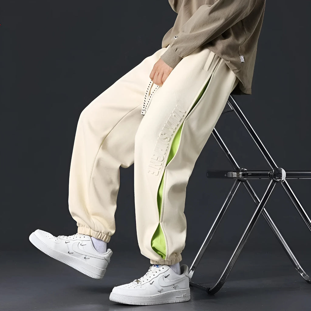 Men's loose-fit cotton trousers with printed stitching detail and ankle banding in grey green colour