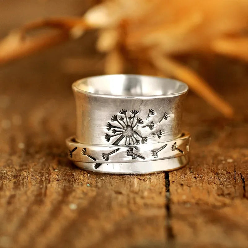 Silver rotating flower ring showing floral element and band details