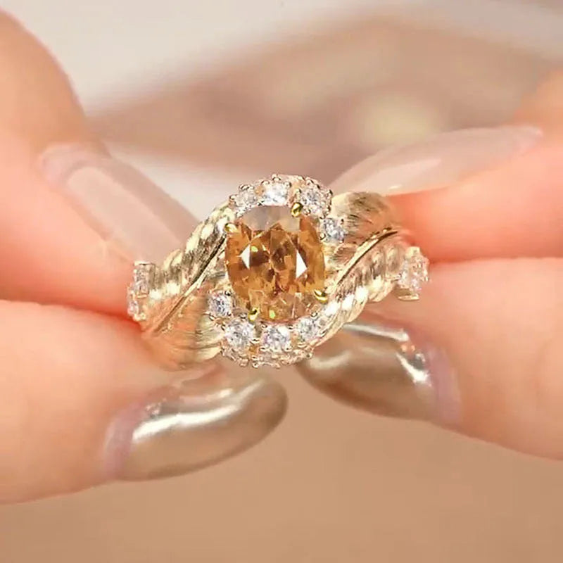 Women's gold-coloured copper ring with embossed feather pattern and yellow zircon stone in geometric setting