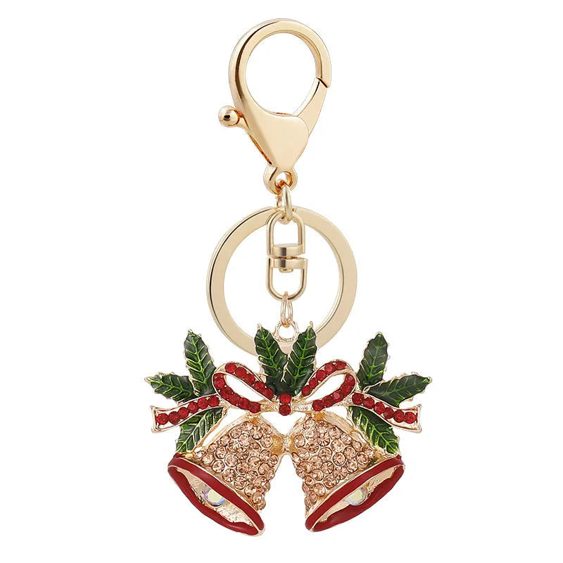 Christmas bell shaped metal keychain with diamond studded surface in champagne colour on white background