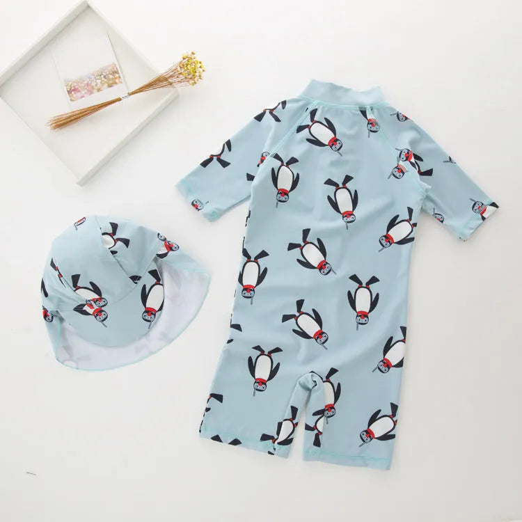 Boys' long-sleeve penguin print swimsuit set with matching swimming cap on mannequin